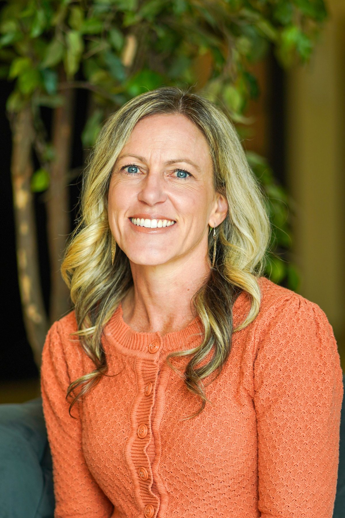 Valerie Hopman smiling, wearing an orange cardigan