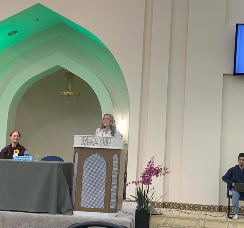 Valerie speaking at a podium at the Voices for Peace event